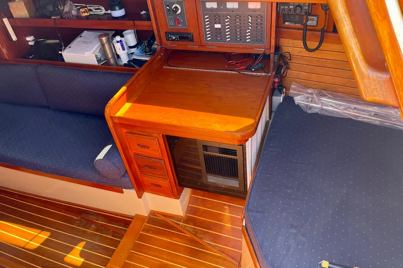 Slide: The Image of Interior of a 1979 Catalina 38 sailboat with wooden cabinetry and blue seating. - 26