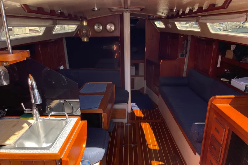 Slide: The Image of Interior of a 1979 Catalina 38 sailboat with wooden furnishings and seating area. - 28