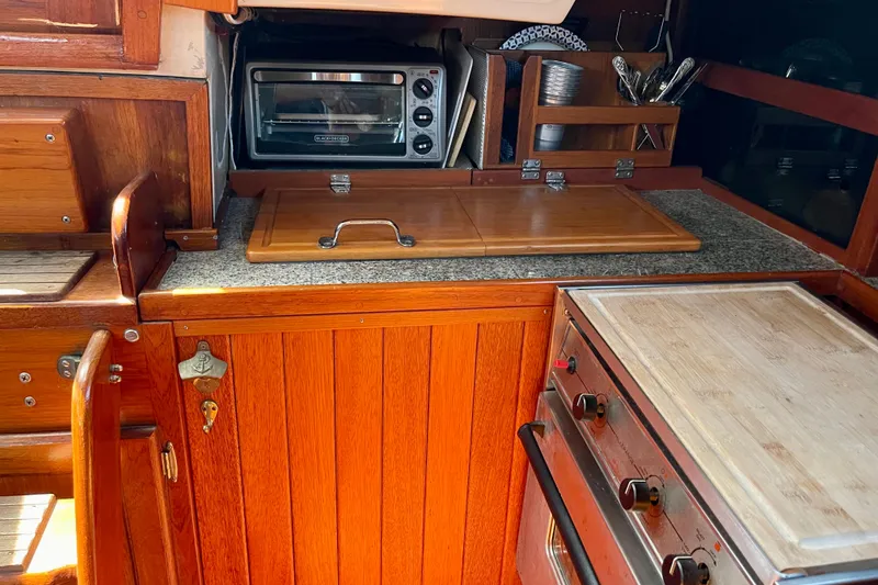 Slide: The Image of Wooden galley kitchen in a 1979 Catalina 38 sailboat with stove and toaster oven. - 32