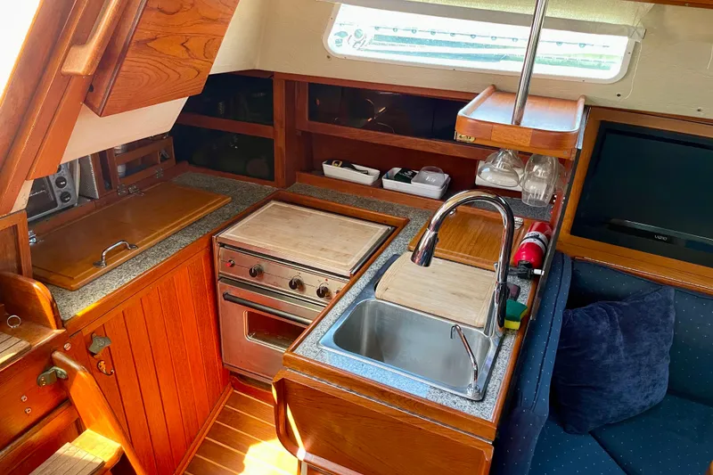 Slide: The Image of Cozy 1979 Catalina 38 yacht kitchen with wood cabinetry, stove, and sink. - 33