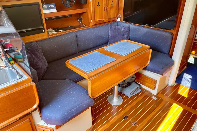 Slide: The Image of Cozy interior of a 1979 Catalina 38 sailboat with wooden table and cushioned seating. - 36