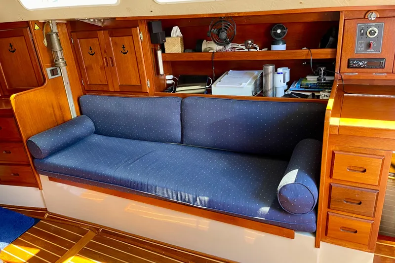 Slide: The Image of Interior of a 1979 Catalina 38 sailboat with blue cushioned seating and wooden cabinetry. - 37