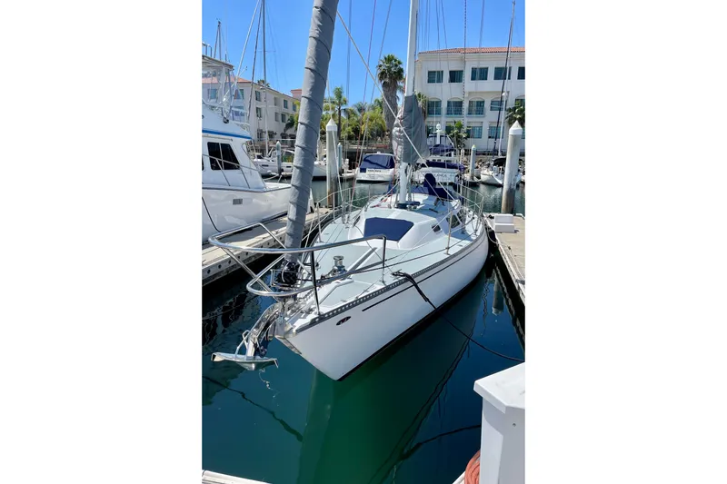 Slide: The Image of 1979 Catalina 38 sailboat docked in marina, surrounded by other boats. - 4