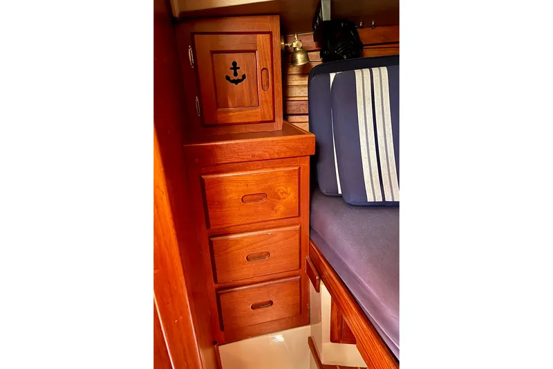 Slide: The Image of Wooden cabin interior of 1979 Catalina 38 sailboat with drawers and striped cushion. - 44