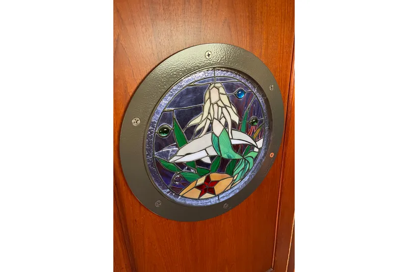 Slide: The Image of Stained glass porthole on 1979 Catalina 38, featuring floral design. - 46