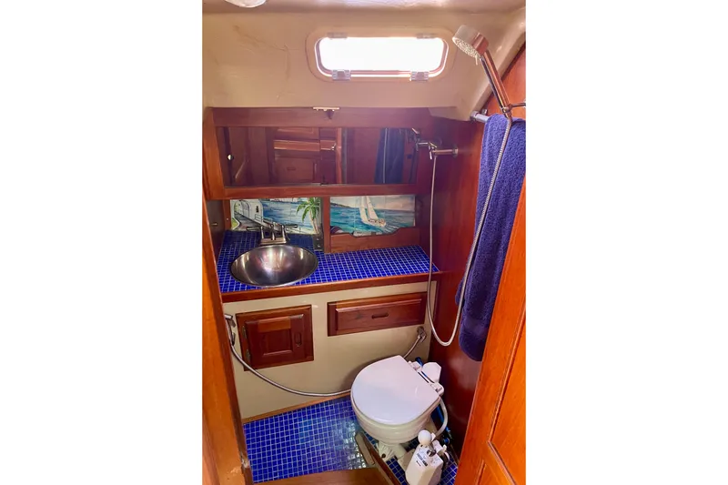 Slide: The Image of 1979 Catalina 38 yacht bathroom with blue tiles, sink, and toilet. - 47