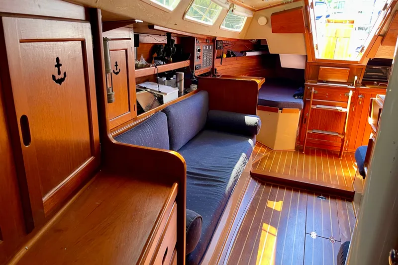Slide: The Image of Interior of a 1979 Catalina 38 sailboat with wooden cabinetry and navy seating. - 48