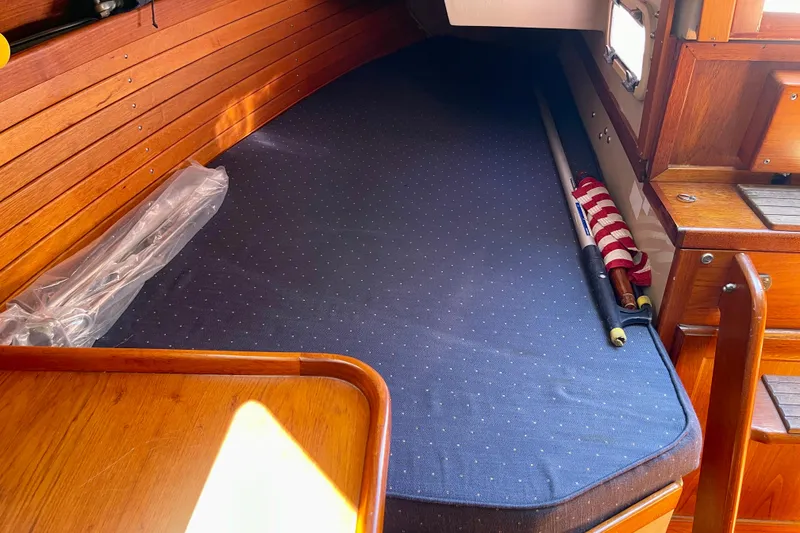 Slide: The Image of Cozy cabin interior of a 1979 Catalina 38 sailboat with wooden accents and a blue mattress. - 50