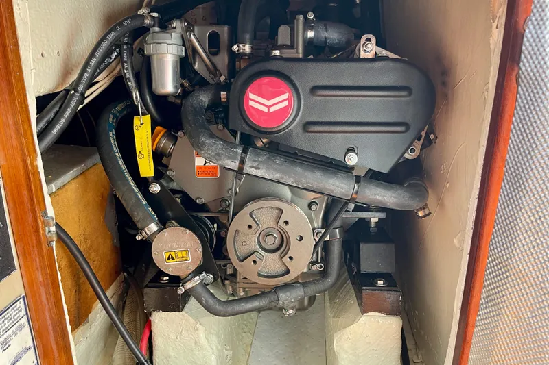 Slide: The Image of Engine compartment of a 1979 Catalina 38 sailboat, showcasing mechanical components and hoses. - 51