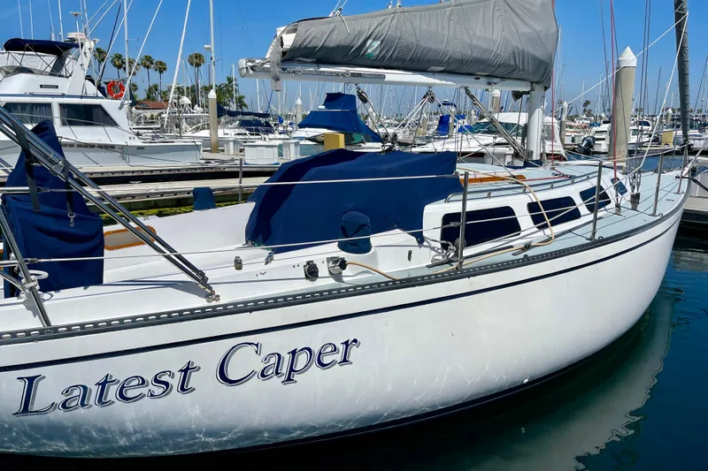 Slide: The Image of 1979 Catalina 38 sailboat named "Latest Caper" docked in a marina. - 8
