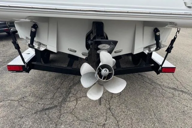 Slide: The Image of 2025 Crownline 280 SS boat stern with propeller and trailer on pavement. - 10