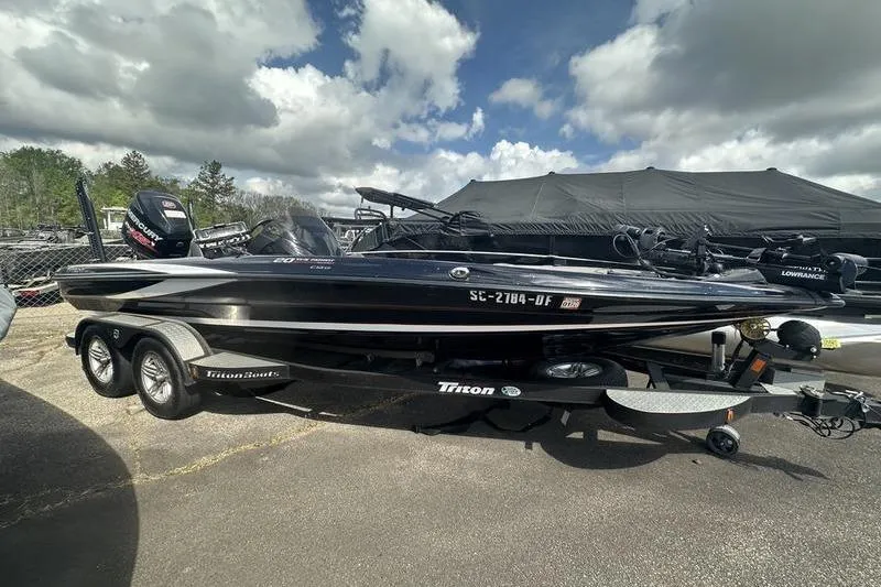 The Image of 2016 Triton 20 TrX bass boat on trailer under cloudy sky. - 0