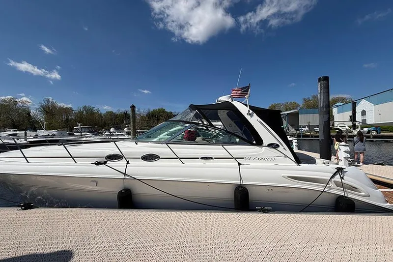 The Image of 2001 Sea Ray 410 Express Cruiser docked at marina under clear blue sky. - 0