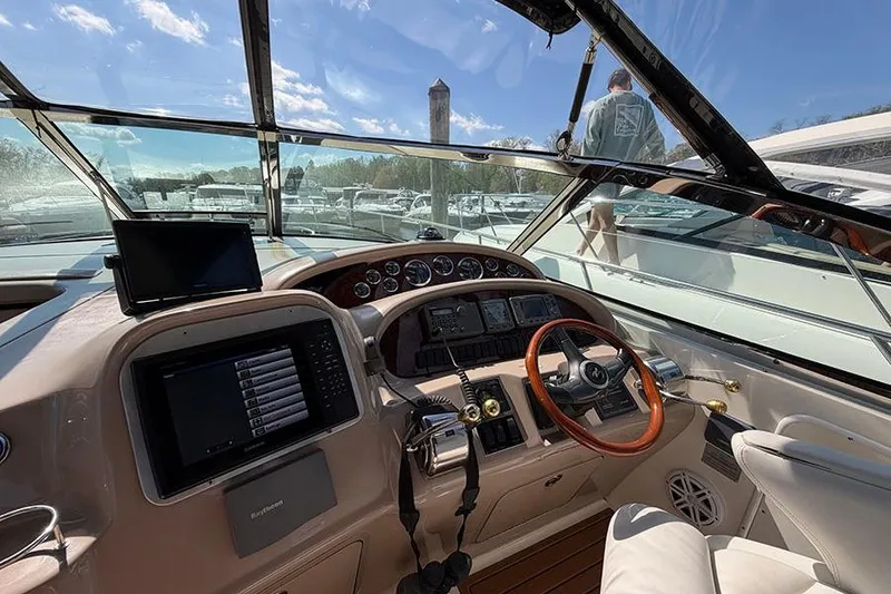 Slide: The Image of Helm of 2001 Sea Ray 410 Express Cruiser with modern navigation equipment and wooden steering wheel. - 10