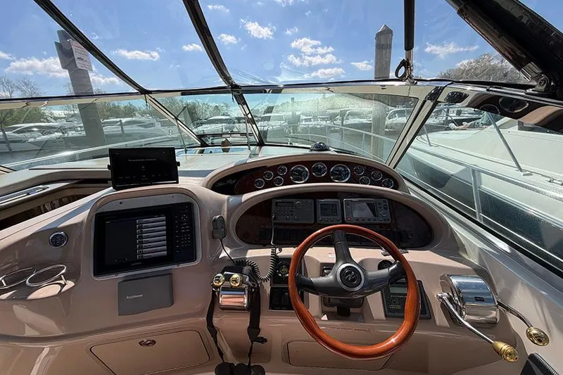 Slide: The Image of Cockpit view of 2001 Sea Ray 410 Express Cruiser with steering wheel and navigation instruments. - 11