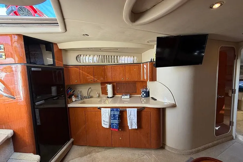 Slide: The Image of Interior of 2001 Sea Ray 410 Express Cruiser with kitchen and mounted TV. - 15