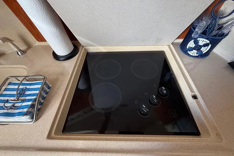 Slide: The Image of Stovetop in 2001 Sea Ray 410 Express Cruiser kitchen with paper towel holder and utensils. - 18