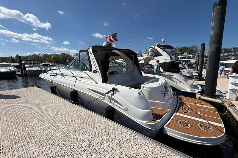 Slide: The Image of 2001 Sea Ray 410 Express Cruiser docked at marina under clear blue sky. - 2