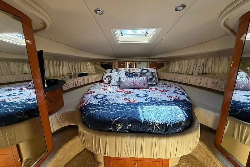 Slide: The Image of Luxurious cabin interior of a 2001 Sea Ray 410 Express Cruiser with nautical-themed bedding. - 20
