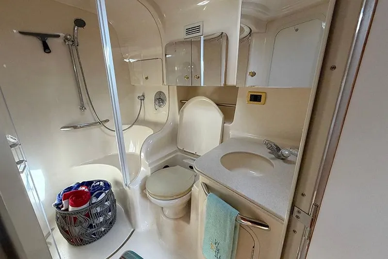 Slide: The Image of 2001 Sea Ray 410 Express Cruiser bathroom with shower, sink, and storage cabinets. - 25