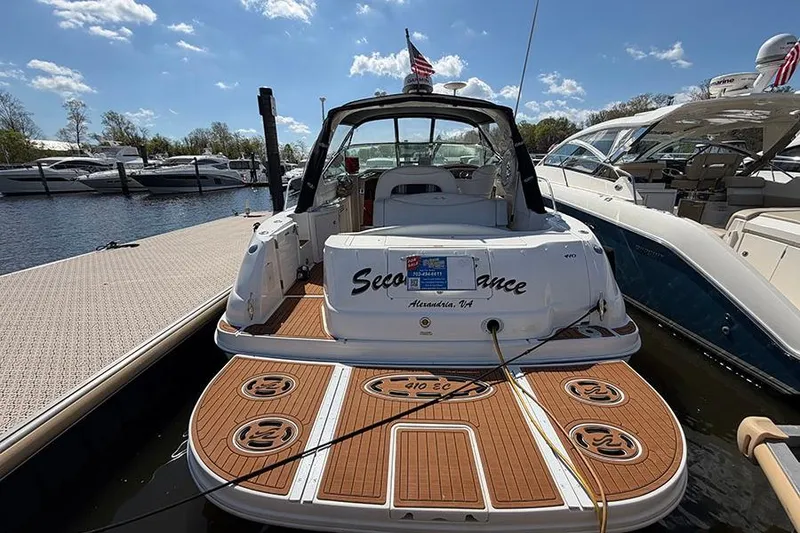 Slide: The Image of 2001 Sea Ray 410 Express Cruiser docked, featuring teak deck and American flag. - 3