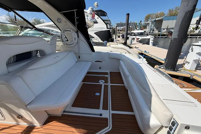 Slide: The Image of 2001 Sea Ray 410 Express Cruiser with white seating and teak flooring at a marina. - 5
