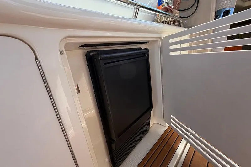 Slide: The Image of 2001 Sea Ray 410 Express Cruiser interior fridge compartment with open door. - 8