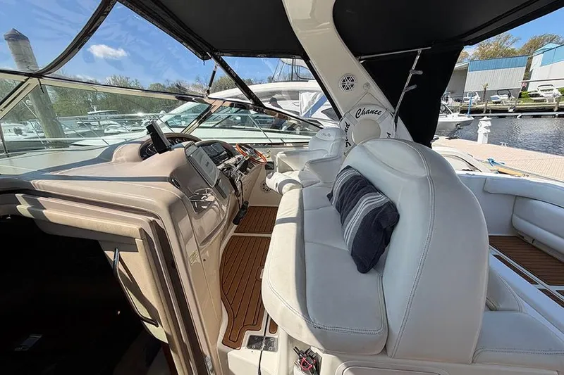 Slide: The Image of 2001 Sea Ray 410 Express Cruiser cockpit with white seating and wooden flooring. - 9