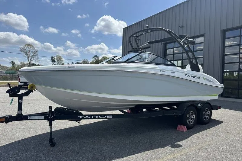The Image of 2024 Tahoe 210 S boat on trailer, parked outdoors under a clear sky. - 0