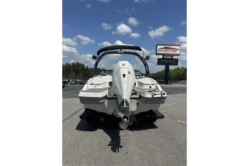 Slide: The Image of 2024 Tahoe 210 S boat rear view in parking lot under blue sky. - 2