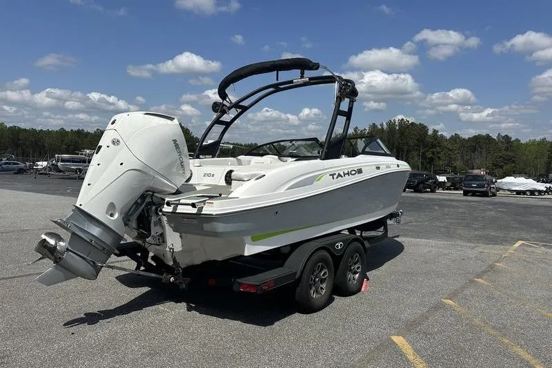 Slide: The Image of 2024 Tahoe 210 S boat on trailer, parked outdoors under a clear sky. - 3