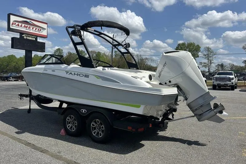 Slide: The Image of 2024 Tahoe 210 S boat on trailer, parked outdoors under a cloudy sky. - 8
