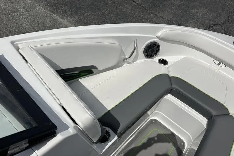 Slide: The Image of 2024 Tahoe 210 S boat interior with white and gray seating, cup holder, and speaker. - 9