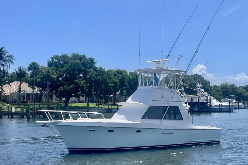The Image of 1968 Hatteras 34 Sport Fisherman boat cruising on a sunny day near a marina. - 1