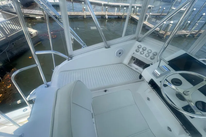 Slide: The Image of 1968 Hatteras 34 Sport Fisherman helm with steering wheel and gauges, docked at marina. - 15