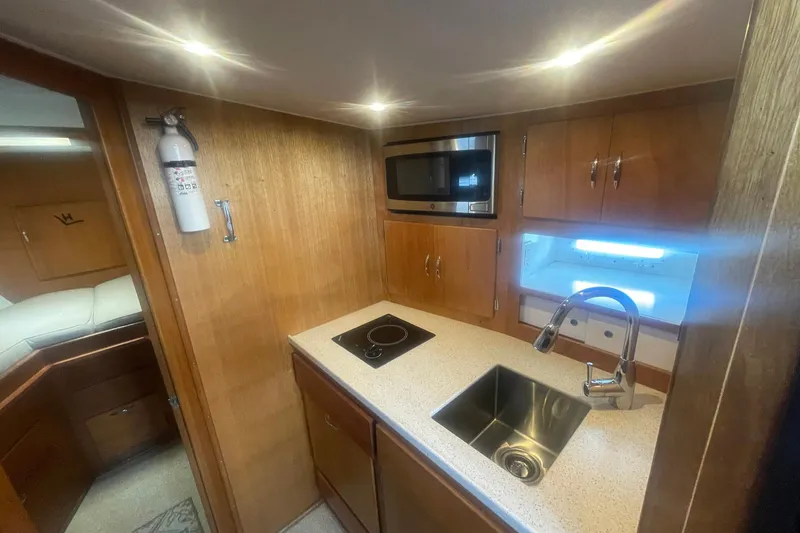 Slide: The Image of 1968 Hatteras 34 Sport Fisherman galley with sink, stovetop, and microwave. - 22