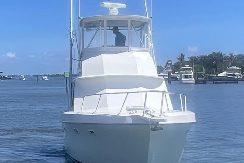 Slide: The Image of 1968 Hatteras 34 Sport Fisherman boat cruising on a sunny day near a marina. - 5