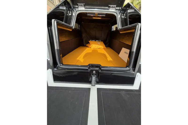 Slide: The Image of Open trunk of Iron 907 (2025) with orange interior bedding setup. - 10