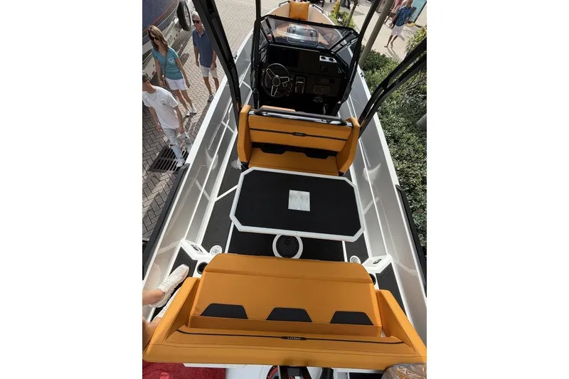 Slide: The Image of Modern Iron 907 boat interior with orange seating and sleek black table, 2025 model. - 12