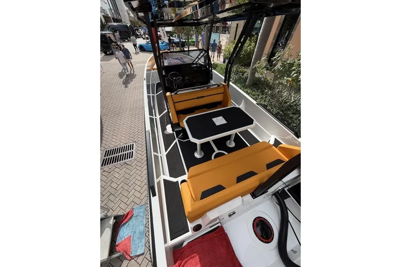 Slide: The Image of Modern Iron 907 boat interior with orange seating and black table, docked in urban setting. - 13