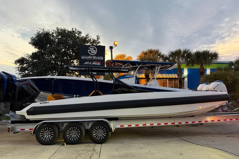 The Image of 2025 Iron 907 boat on trailer, parked outdoors with palm trees in the background. - 6