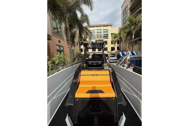 Slide: The Image of Modern Iron 907 boat with orange seating, docked near palm trees and buildings, 2025 model. - 9