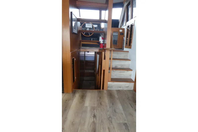 Slide: The Image of Interior of 1989 Angel Pilothouse with wooden stairs and steering wheel. - 10