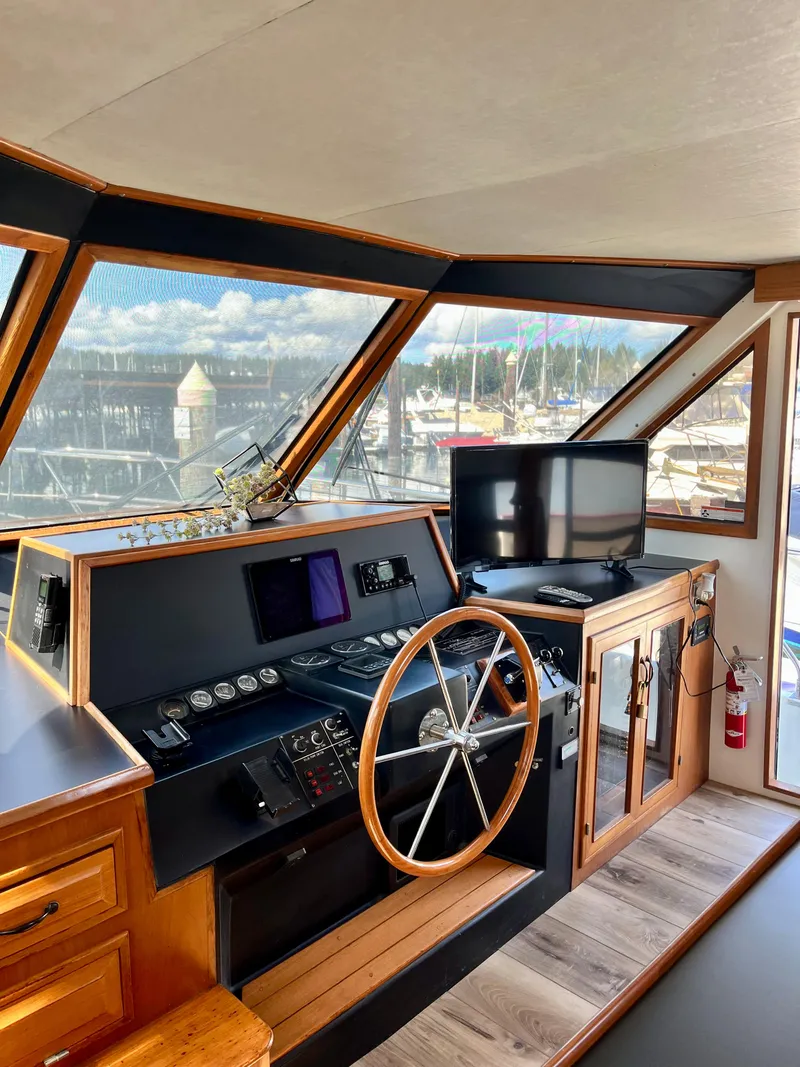 Slide: The Image of 1989 Angel Pilothouse interior with steering wheel, control panel, and marina view. - 14