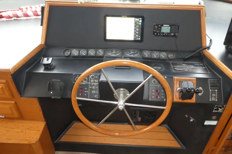 Slide: The Image of 1989 Angel Pilothouse helm with wooden steering wheel and navigation instruments. - 15