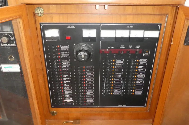 Slide: The Image of Electrical control panel on a 1989 Angel Pilothouse boat, featuring switches and meters. - 17