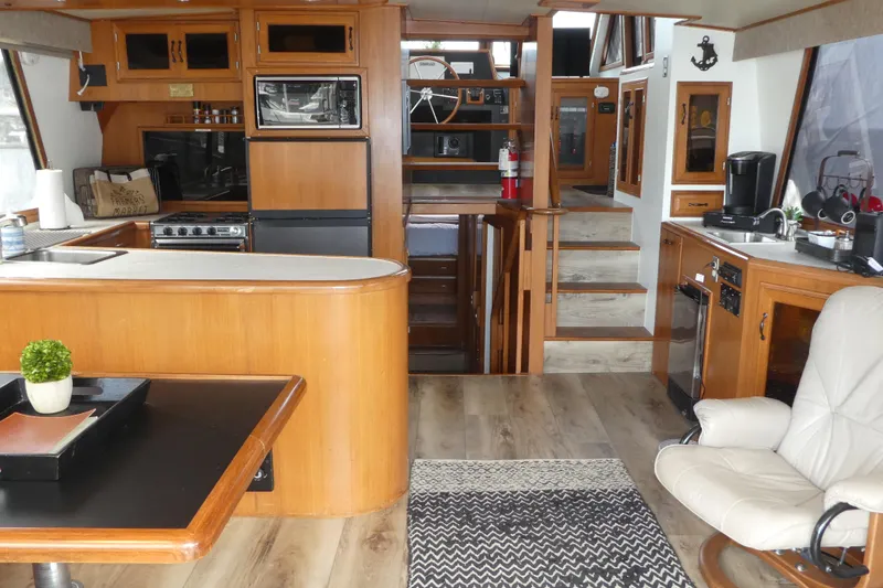 Slide: The Image of Luxurious 1989 Angel Pilothouse interior with modern kitchen, wooden cabinetry, and comfortable seating. - 21