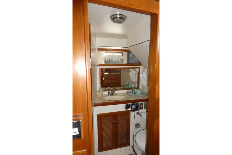 Slide: The Image of 1989 Angel Pilothouse bathroom with wooden cabinetry, sink, and mirror. - 23