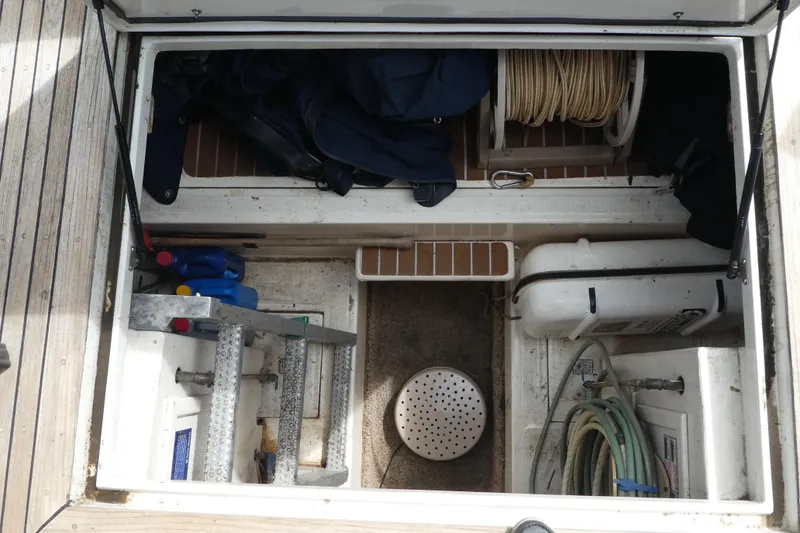 Slide: The Image of Storage compartment of a 1989 Angel Pilothouse boat with equipment and supplies. - 34