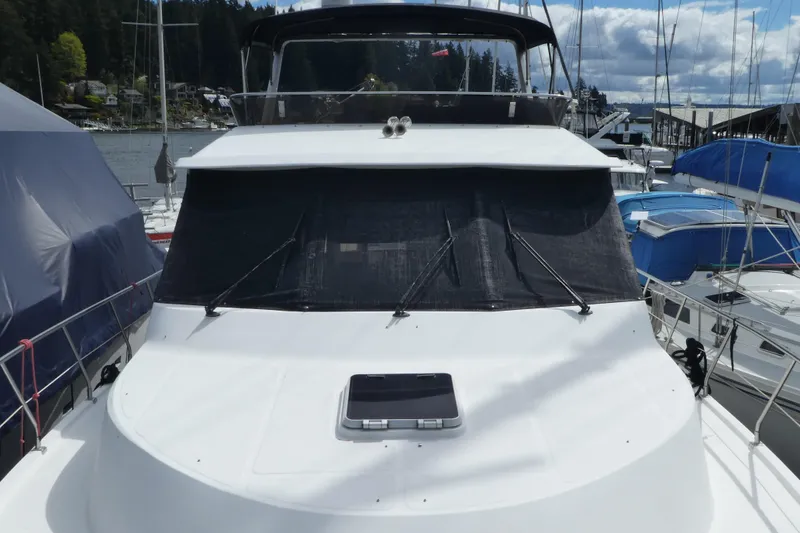 Slide: The Image of 1989 Angel Pilothouse yacht docked at marina, surrounded by other boats under cloudy sky. - 47